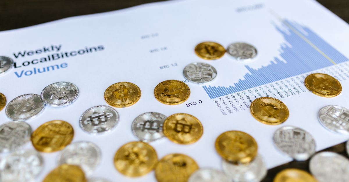 Gold and silver Bitcoin coins placed on a graph showing LocalBitcoins trading volume analysis, symbolizing cryptocurrency market trends.